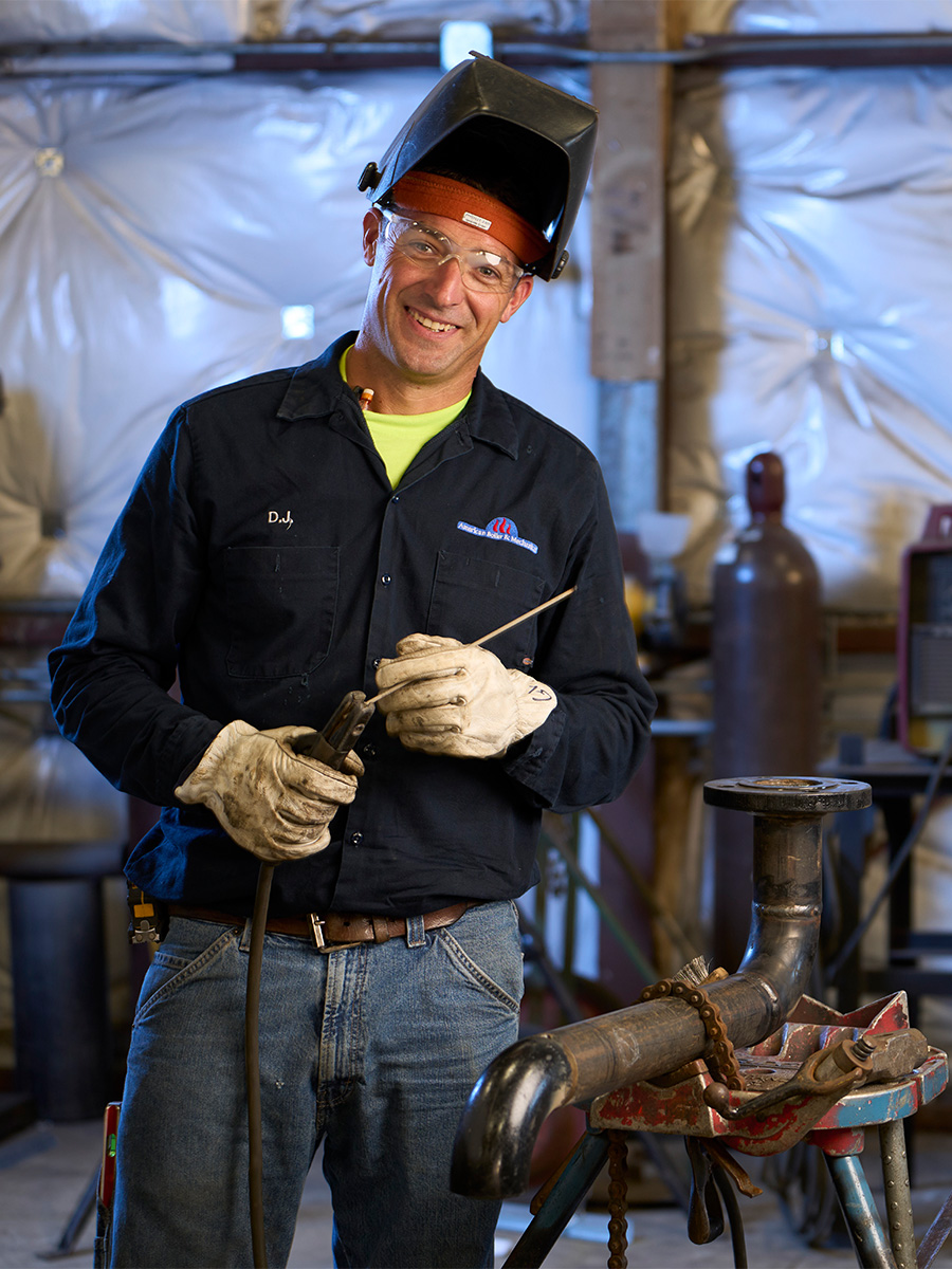 history-spot man with welding mask on, smiling